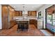 Kitchen features island, wood cabinetry, and terracotta floors at 7957 E Cave Creek Rd, Carefree, AZ 85377