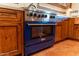 Blue range and wood cabinetry in kitchen at 7957 E Cave Creek Rd, Carefree, AZ 85377