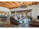 Leather sofas, wood beams, fireplace, and backyard access at 7957 E Cave Creek Rd, Carefree, AZ 85377