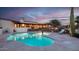 Evening view of the pool and home with lights at 7957 E Cave Creek Rd, Carefree, AZ 85377