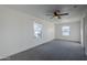 Spacious bedroom with ceiling fan, carpet, and window with street view at 8230 W Monterey Way, Phoenix, AZ 85033