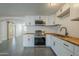 Modern kitchen with white shaker cabinets, butcher block countertops, and stainless steel appliances at 8230 W Monterey Way, Phoenix, AZ 85033