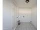 Laundry room with tiled floor and built-in shelving at 8230 W Monterey Way, Phoenix, AZ 85033