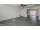 Open living room with gray tile floors, a ceiling fan, and an arched doorway at 8230 W Monterey Way, Phoenix, AZ 85033