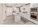 Modern kitchen with white cabinets, center island, and stainless steel appliances at 8435 E Catalina Dr, Scottsdale, AZ 85251