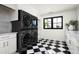 Modern laundry room with black appliances and checkerboard floor at 8601 N 64Th Pl, Paradise Valley, AZ 85253