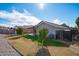 Backyard view showing patio, grass, trees, and playset at 8828 E Des Moines St, Mesa, AZ 85207