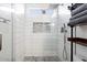 Modern shower with white tile, glass enclosure, and built-in shelf at 8828 E Des Moines St, Mesa, AZ 85207