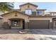 Two-story house with a brown garage door and string lights at 9420 S 35Th Gln, Laveen, AZ 85339