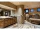 Primary bathroom with double vanities, large soaking tub, and stone flooring at 9839 E Madera E Dr, Scottsdale, AZ 85262