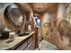 Southwest style bathroom with copper sink, stone tile, and Native American artwork at 9839 E Madera E Dr, Scottsdale, AZ 85262