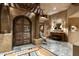 Grand entryway with arched wood door and stone flooring at 9839 E Madera E Dr, Scottsdale, AZ 85262