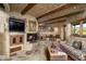 Cozy living room with a stone fireplace and wood beams at 9839 E Madera E Dr, Scottsdale, AZ 85262