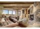 Rustic living room with a stone fireplace and large windows at 9839 E Madera E Dr, Scottsdale, AZ 85262