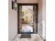 Ornate front door opens to a view of the dining room and chandelier at 10054 E Cinnabar Ave, Scottsdale, AZ 85258