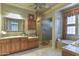 Elegant bathroom with double sinks, a soaking tub, and a walk-in shower at 12617 W Mine Trl, Peoria, AZ 85383