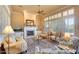 Elegant living room featuring a fireplace, comfortable seating, and abundant natural light from large windows at 12617 W Mine Trl, Peoria, AZ 85383