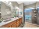 Bathroom with double sinks, granite countertop, and a large walk-in shower at 15827 W Falcon Ridge Dr, Sun City West, AZ 85375