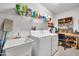 Laundry room with washer, dryer, utility sink, and ample storage at 15827 W Falcon Ridge Dr, Sun City West, AZ 85375