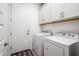 Laundry room with washer, dryer, and upper cabinets at 17734 W Amber Ridge Way, Goodyear, AZ 85338