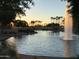 Sunset view of pond with fountain and palm trees at 19957 N Rawhide Way, Surprise, AZ 85387