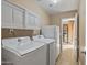 Bright laundry room, featuring washer, dryer, and storage cabinets at 2070 N Don Peralta Rd, Apache Junction, AZ 85119