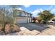 Two-story house with a beige exterior, two-car garage, and landscaping at 219 E Beth Dr, Phoenix, AZ 85042