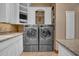 Bright laundry room with built-in cabinets and modern washer and dryer at 2333 S Eileen Pl, Chandler, AZ 85286