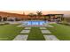 Relaxing backyard featuring a pool, outdoor kitchen, and green turf at 31023 N 117Th Dr, Peoria, AZ 85383