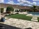 Landscaped backyard with pool, artificial turf, and patio at 31023 N 117Th Dr, Peoria, AZ 85383