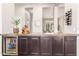 Modern bar area with brown cabinets, a beverage fridge, wine rack and decorative decor at 31023 N 117Th Dr, Peoria, AZ 85383