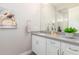 Bathroom featuring a gray countertop, white cabinets, and a decorative floral artwork at 31023 N 117Th Dr, Peoria, AZ 85383