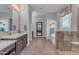 Bathroom with dual vanities, large tub, and a glass-enclosed shower at 31023 N 117Th Dr, Peoria, AZ 85383