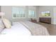 Bright bedroom featuring shuttered windows, hardwood floors, dresser and a comfortable sitting area at 31023 N 117Th Dr, Peoria, AZ 85383
