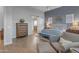 Bright and stylish bedroom with a blue accent wall, a chair, and ensuite bathroom at 31023 N 117Th Dr, Peoria, AZ 85383