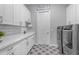 Bright laundry room with modern washer and dryer, white cabinets, and patterned tile floor at 31023 N 117Th Dr, Peoria, AZ 85383