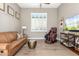 Comfortable living room featuring a leather sofa, massage chair, and plantation shutters at 31023 N 117Th Dr, Peoria, AZ 85383