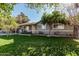 Front view of a house with a grassy lawn and trees at 3601 W Solano Dr, Phoenix, AZ 85019
