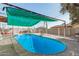 Inviting oval swimming pool with green shade cover at 3601 W Solano Dr, Phoenix, AZ 85019