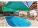 Inviting kidney-shaped pool with shade cover; perfect for relaxation at 3601 W Solano Dr, Phoenix, AZ 85019