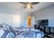 Bedroom with a ceiling fan, gray bedding, and a TV at 3798 E Latham Ct, Gilbert, AZ 85297