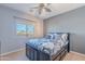 Bedroom with a ceiling fan, gray bedding, and a window view at 3798 E Latham Ct, Gilbert, AZ 85297