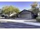 Single-story home with a two-car garage and mature trees in the front yard at 4111 E Tether Trl, Phoenix, AZ 85050