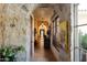 Long hallway with stone walls and artwork at 66 Biltmore Est, Phoenix, AZ 85016