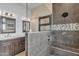 Stylish bathroom featuring double sinks, modern lighting, tiled shower with built-in seat at 665 N Wyatt Dr, Chandler, AZ 85226