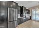 Open concept kitchen with stainless steel fridge and appliances, dark wood cabinets, and tile floor at 665 N Wyatt Dr, Chandler, AZ 85226