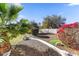 Landscaped area with gravel pathway, palm trees, and flowers at 8027 E Juan Tabo Rd, Scottsdale, AZ 85255