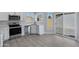 Modern white kitchen with stainless steel appliances and grey vinyl plank flooring at 1055 N Recker Rd # 1215, Mesa, AZ 85205