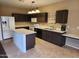 Kitchen with island, dark cabinets, and tile floors at 11432 E Quicksilver Ave, Mesa, AZ 85212