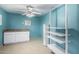 Bright blue laundry room with white cabinets and shelving at 13428 N 36Th Pl, Phoenix, AZ 85032